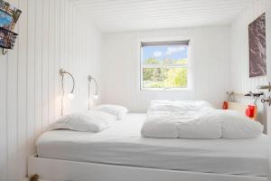 two beds in a white room with a window at FY147-Middelfart-Antaresvej-6 in Middelfart