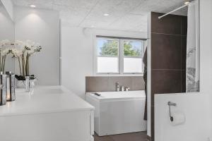 a white bathroom with a sink and a bath tub at FY147-Middelfart-Antaresvej-6 in Middelfart +12 photos