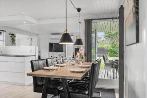 a dining room table with chairs and a kitchen at FY147-Middelfart-Antaresvej-6 in Middelfart