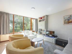 a living room with chairs and a couch and a table at Duinengolf - Zeeanemoon 10 in Westende