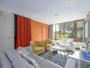 a living room with couches and chairs and a table at Duinengolf - Zeeanemoon 10 in Westende