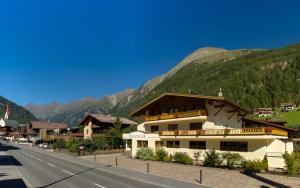 a building on the side of a road next to a mountain at Ferienhaus Austria in Sölden