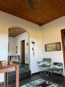 a room with two chairs and a table and a wooden ceiling at Pousada Canastra Raíz in Delfinópolis