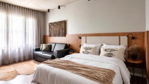 a bedroom with a large bed and a chair at Refúgio Boutique com Piscina Aquecida in Canela +39 photos