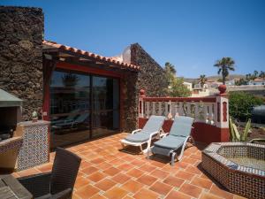 a patio with two lounge chairs and a fireplace at Casa Zapato in La Pared