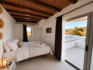 a bedroom with a bed and a balcony at iLocal Premium Services suite in Zefiría