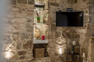 eine Wand mit einem TV an einer Steinmauer in der Unterkunft Apartment Lara in Split