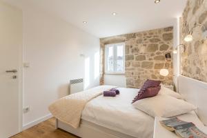 ein Schlafzimmer mit einem Bett und einer Steinwand in der Unterkunft Apartment Lara in Split