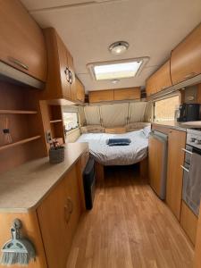 a small kitchen with a bed in a caravan at Little hideaway in Costa da Caparica +7 photos