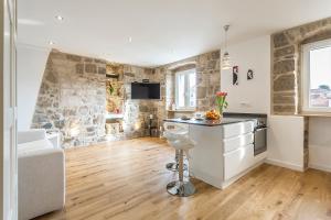 eine Küche und ein Wohnzimmer mit einer Steinmauer in der Unterkunft Apartment Lara in Split