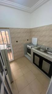 a kitchen with a sink and a stove at New ACROPOLE APPART in Komé