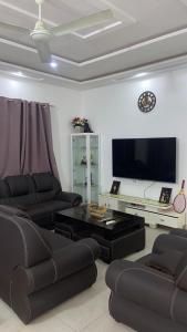 a living room with two couches and a flat screen tv at New ACROPOLE APPART in Komé +5 photos