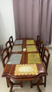 a wooden table with four chairs around it at New ACROPOLE APPART in Komé