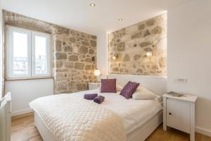ein Schlafzimmer mit einem Bett und einer Steinwand in der Unterkunft Apartment Lara in Split