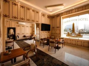 a hotel lobby with tables and chairs and a television at Lumina View Hotel by Tahrir - Downtown in Cairo