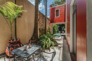 a table and chairs on a patio with palm trees at Casa Zafiro Hotel - Adults Only, Mérida in Mérida