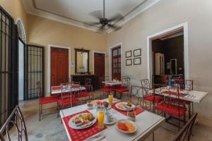 a dining room with tables and chairs with food on them at Casa Zafiro Hotel - Adults Only, Mérida in Mérida