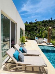 a patio with chaise lounge chairs and a swimming pool at Sol del Este Luxury by SH in San Andrés