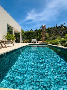 a swimming pool with blue tiles in a house at Sol del Este Luxury by SH in San Andrés