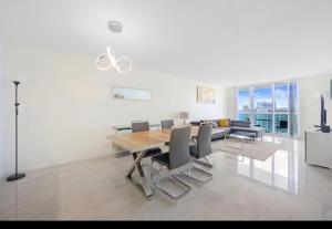 a living room with a wooden table and chairs at Ocean Reserve Miami Sunny Isles Collins Ave in Sunny Isles Beach
