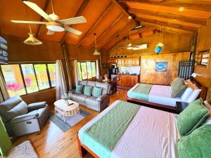 a living room with a large bed and a couch at Sigasiga Sands Boutique Bungalows in Savusavu