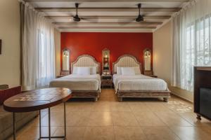 a hotel room with two beds and a table at Casa Zafiro Hotel - Adults Only, Mérida in Mérida +32 photos