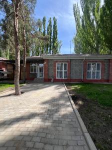 a brick house with a tree in front of it at РадугаВест58а in Koshkolʼ