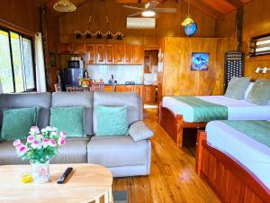 a living room with two beds and a couch at Sigasiga Sands Boutique Bungalows in Savusavu