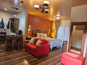 a large bedroom with a bed and a red chair at Finca La Concepción in Marcala