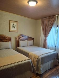 a hotel room with two beds and a window at Finca La Concepción in Marcala +5 photos
