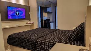 a bedroom with a bed and a flat screen tv at Transpark Juanda by Aqillaroom in Padurenan
