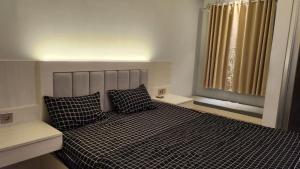 a bedroom with a bed with two pillows and a window at Transpark Juanda by Aqillaroom in Padurenan
