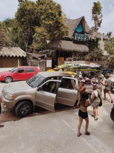 a group of people standing around a car with surfboards on it at La Redonda Surf Hostel Sayulita in Sayulita