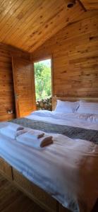 two beds in a room with wooden walls at Luna Valley Homestay in Sapa