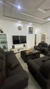 a living room with couches and a flat screen tv at New ACROPOLE APPART in Komé