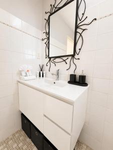 a white bathroom with a sink and a mirror at Alex Headland Unit Views to the Ocean in Alexandra Headland +21 photos