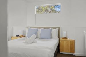 a white bed with white pillows and a window at The View in Lorne +32 photos