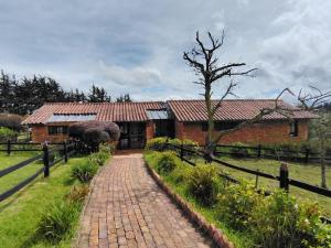 a brick house with a brick pathway leading to it at La Toscana, Chalet Campestre in Guasca