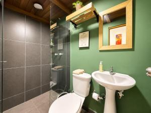 a green bathroom with a toilet and a sink at La Gruta Coliving in Medellín +62 photos