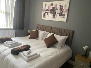 a bed with two towels and pillows on it at Holiday home with 3 double bedrooms all En-suite in Craven Arms