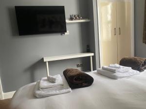 a room with a bed with towels and a tv at Holiday home with 3 double bedrooms all En-suite in Craven Arms +28 photos