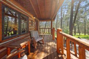 a porch of a log cabin with a table and chairs at Moose Hollow Studio Cabin in Eureka