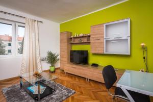 a living room with a tv and a green wall at APARTMENT "Patricia" in Split