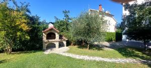 a garden with a small building and a tree at Ruža Vacation House in Međugorje