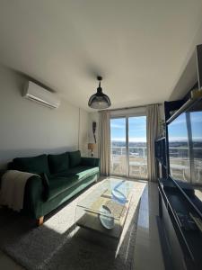 a living room with a green couch and a glass table at Luxury in Villa Carlos Paz