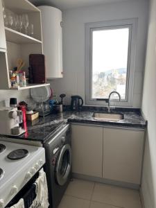 a kitchen with a sink and a washing machine at Luxury in Villa Carlos Paz