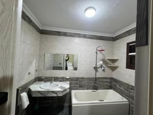 a bathroom with a tub and a sink at Akhnaton pyramids inn in Cairo +54 photos
