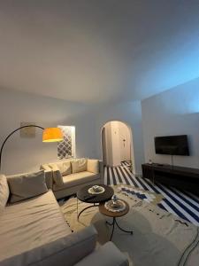 a living room with a couch and a tv at Cosy 1BD Pool, Beach, Large Terrace in Hammam Sousse