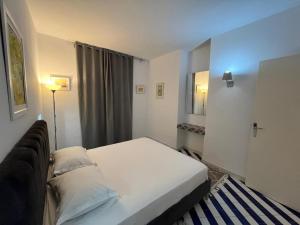 a bedroom with a white bed and a blue light at Cosy 1BD Pool, Beach, Large Terrace in Hammam Sousse