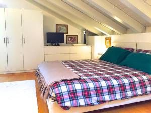 1 dormitorio con 1 cama y TV. en La Mansarda di Margherita, en Treviso